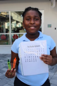 Kayla with her braille crayon